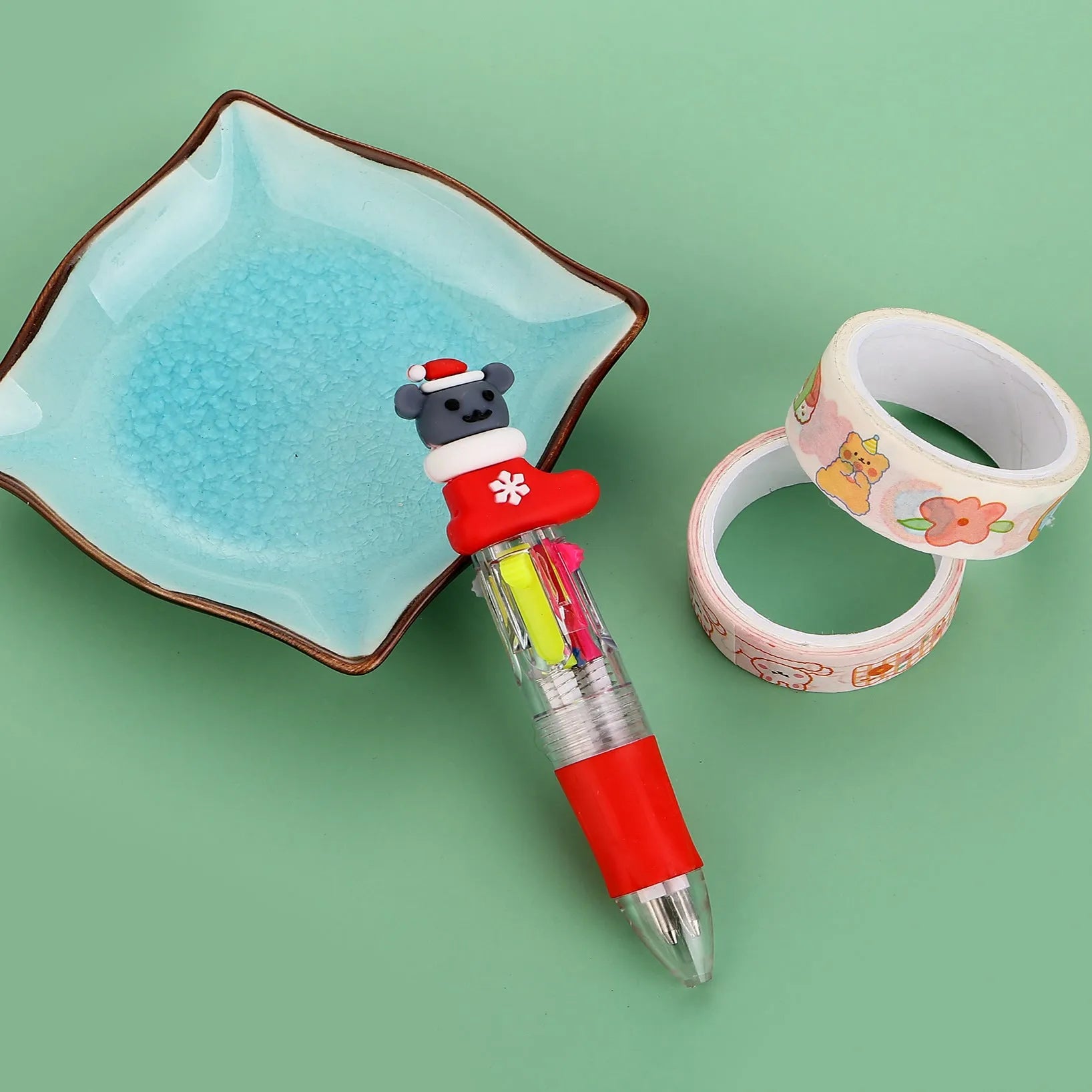 Christmas-themed ballpoint pen with press button, showing designs of snowmen, reindeer, and trees on plastic barrel.