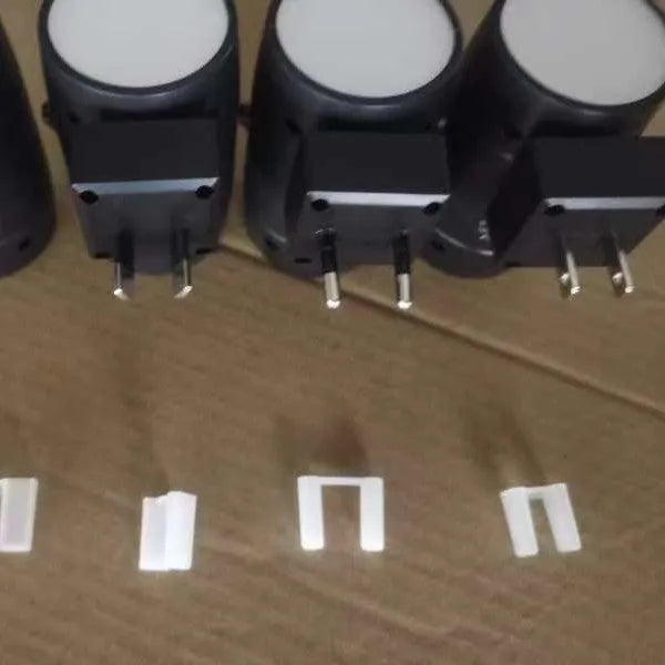 Small white induction night lamp with adjustable brightness dial and rotatable head plugged directly into wall socket