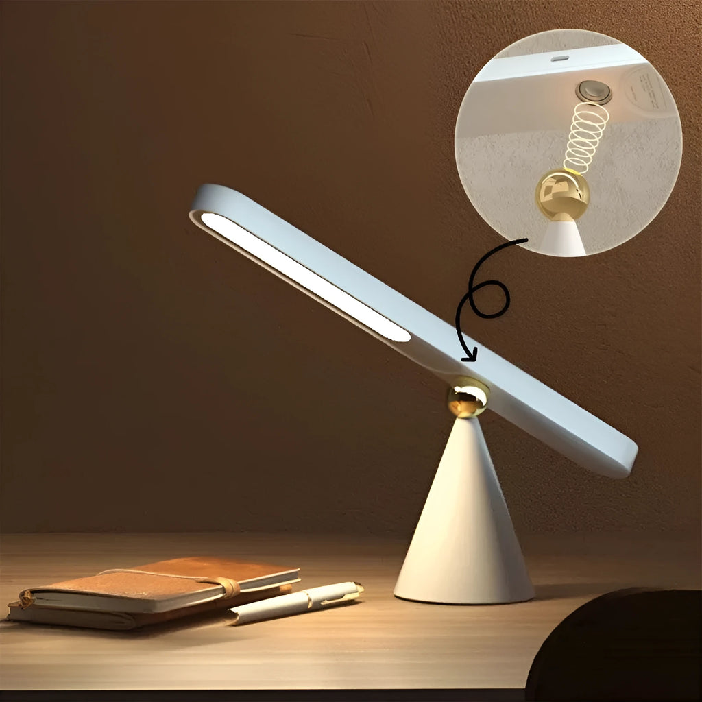 White geometric USB desk lamp with magnetic base shown on a wooden desk.