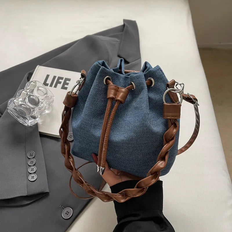 Blue one-shoulder cross body bucket messenger bag with an external sandwich pocket.