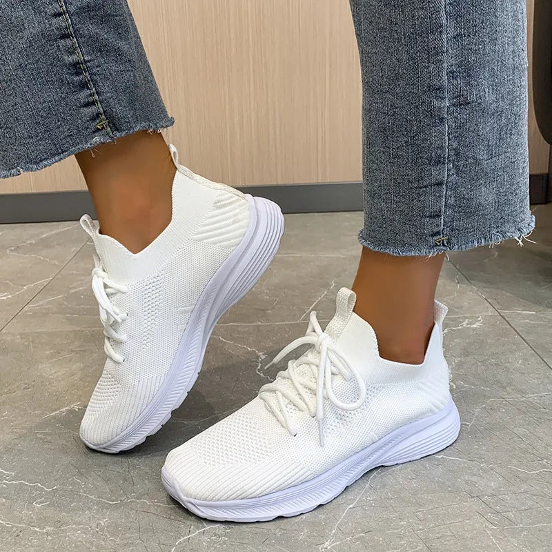 Women's creamy white Flyknit running shoes with mesh lining and low-top design on a rubber sole
