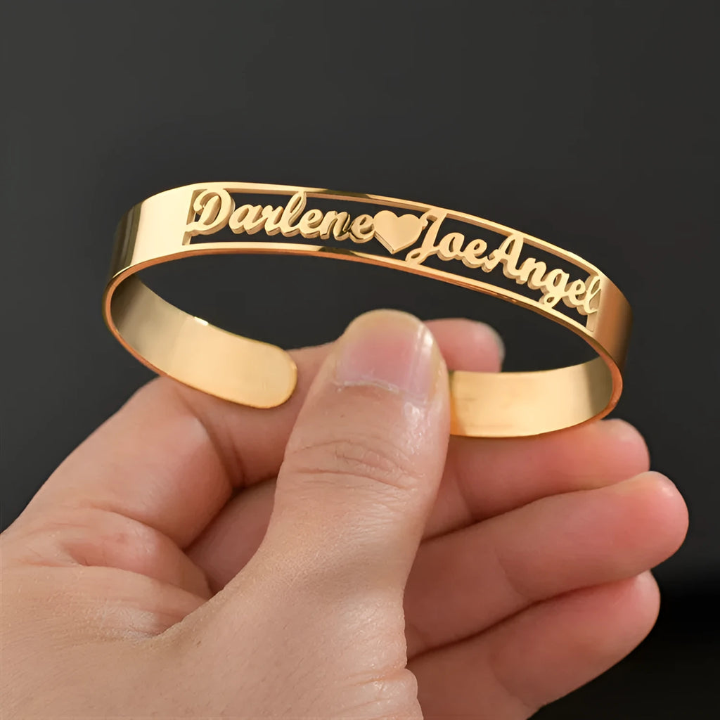 Custom engraved name bangle in stainless steel, silver colour finish, shown on a flat surface
