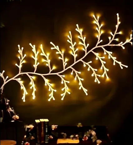 Flexible birch bark textured LED willow vine garland bent into shape with warm white lights.