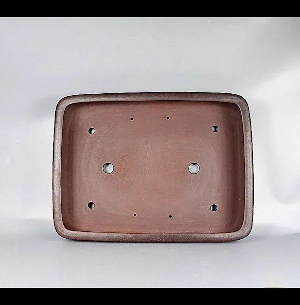 Handmade antique rectangular purple clay flower pot on tabletop