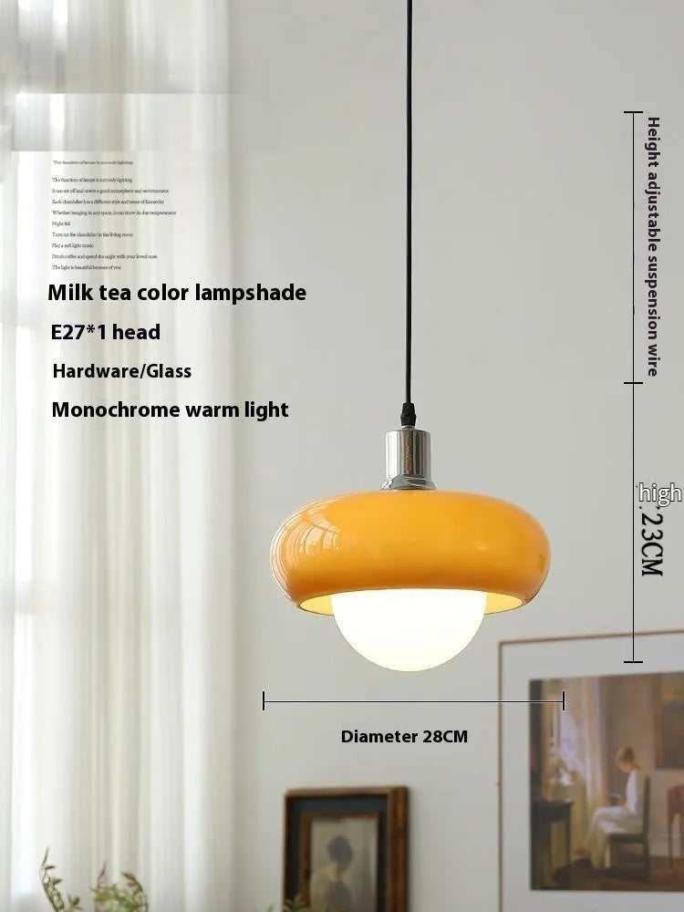 Three-headed Bauhaus pendant light with milky white glass egg tart shades hanging from a ceiling.