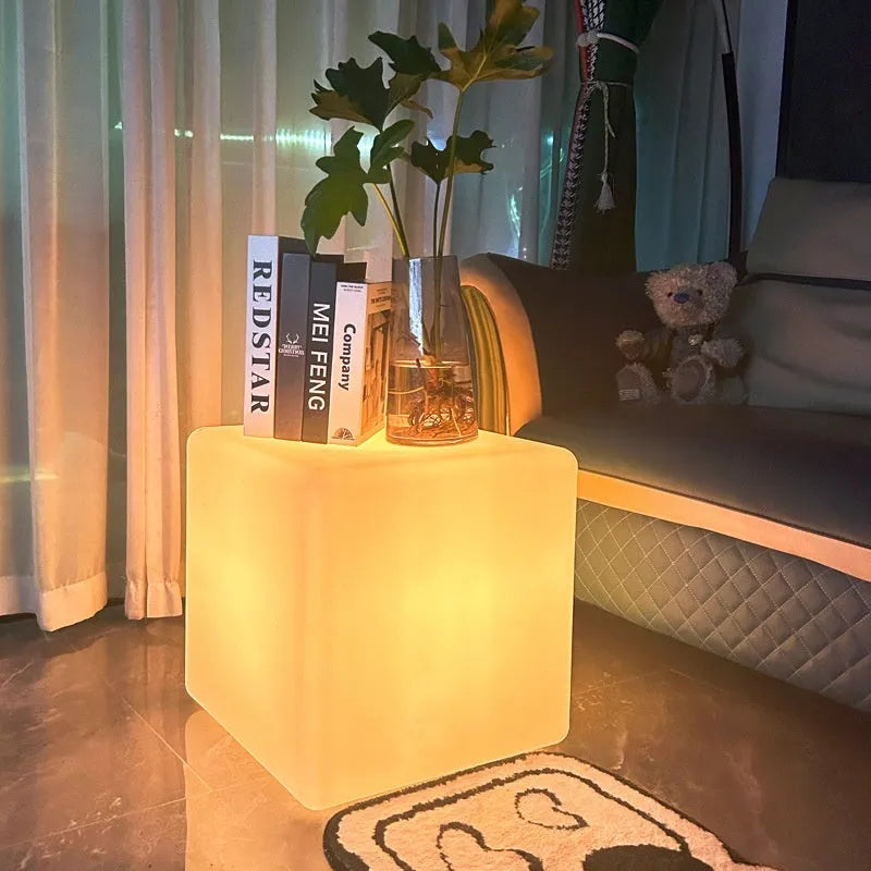 White square LED cube stool light for outdoor use, showing modern design with solar panel or charging port.