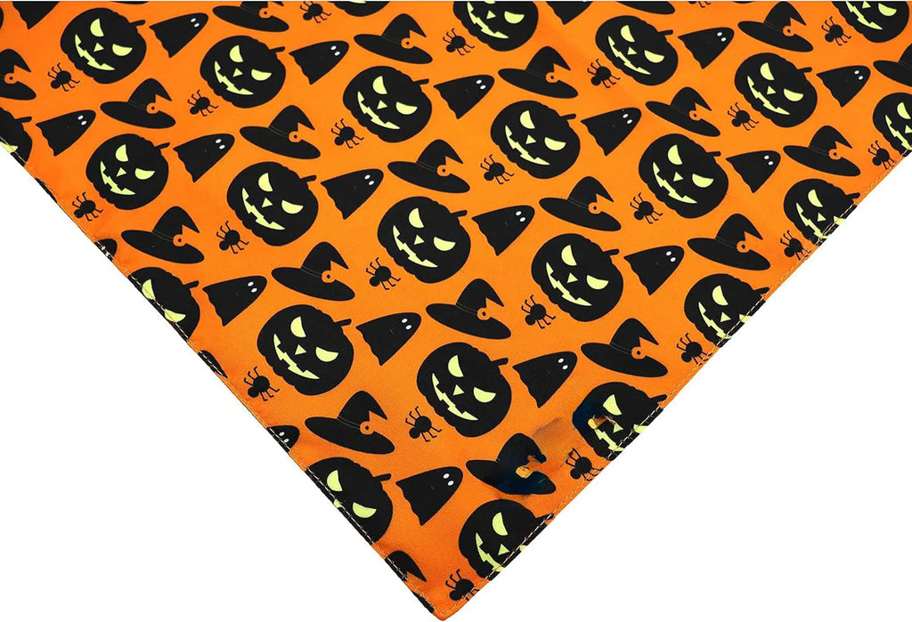 Black and orange reversible Halloween dog bandana with pumpkin and spider web patterns lying flat.