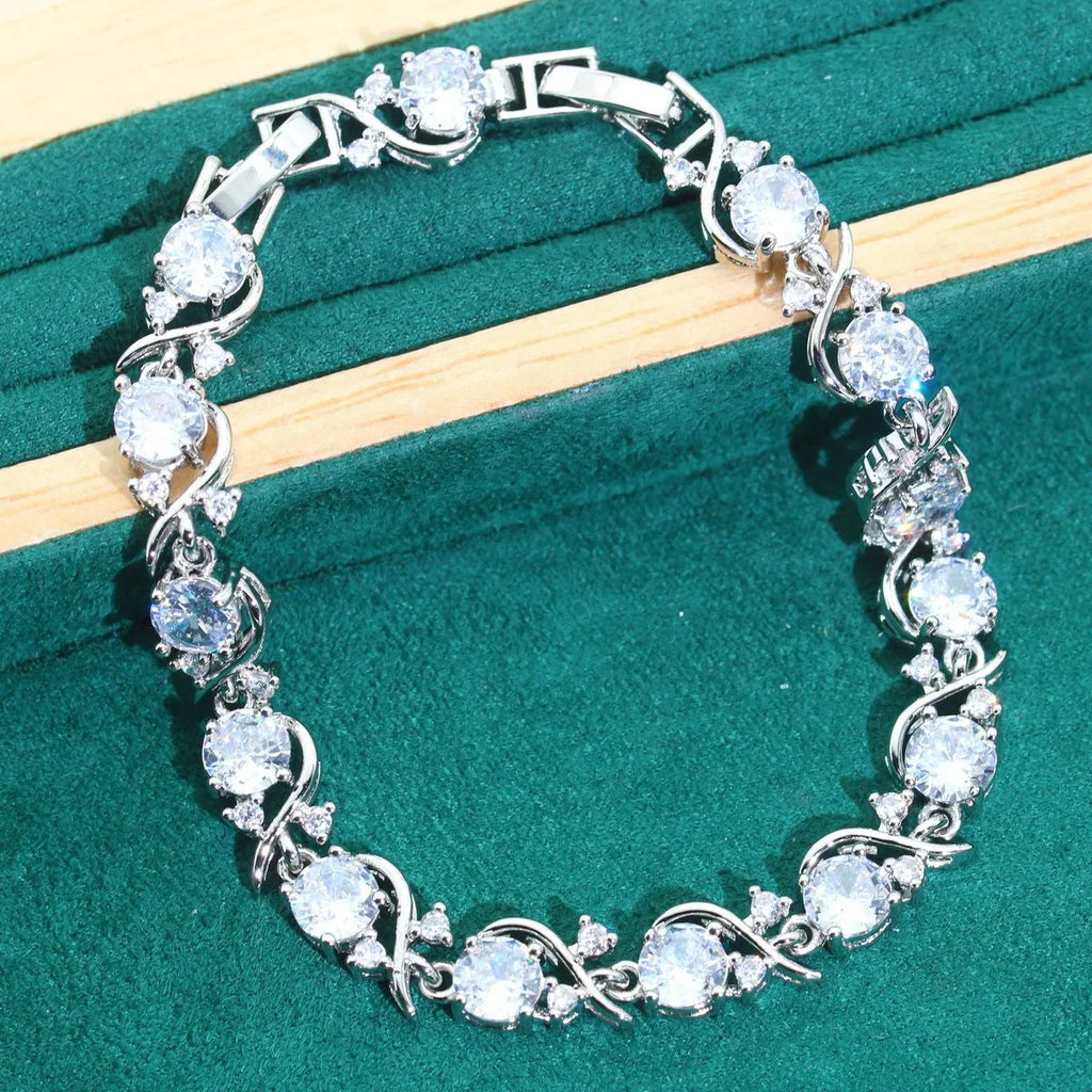 Four-piece bridal jewellery set showing necklace, earrings, ring, and bracelet with zircon alloy pendants