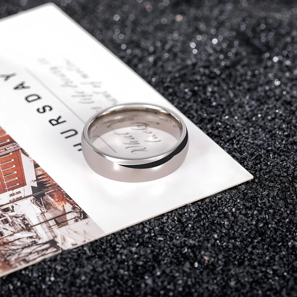 Silver titanium steel band ring shown in three widths: slim 2mm, standard 4mm, and wide 6mm on a plain background.