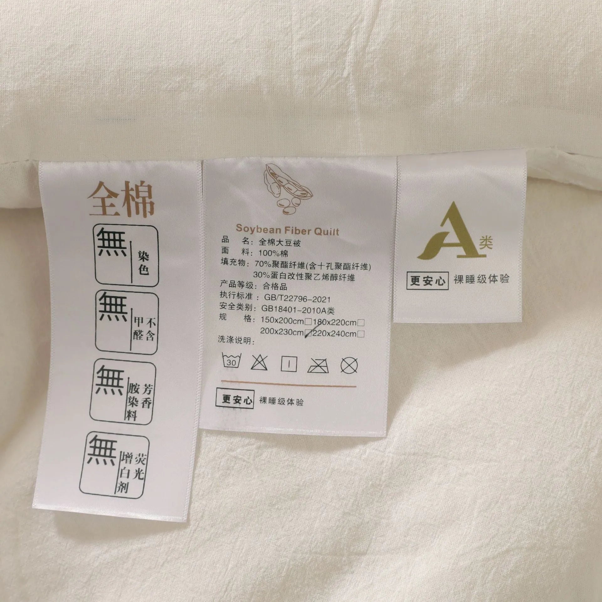 A pure cotton soybean fibre airable quilt in grey, shown with a zipper detail, on a bed.