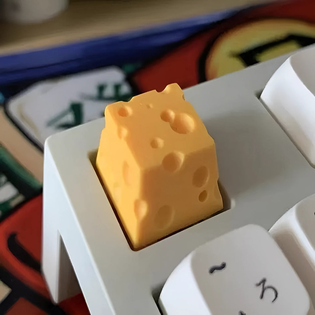 Yellow resin cheese artisan keycap for mechanical keyboards on a white background.