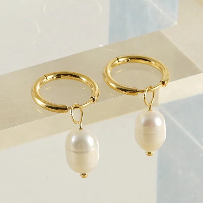 Geometric gold stainless steel earrings with pearl accents on white background