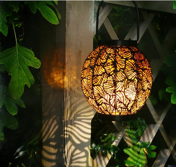 Solar-powered iron courtyard lamp with decorative hollow design and warm white LED lighting