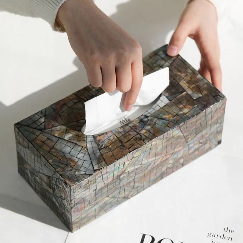 Black rectangular natural shell tissue box storage container with removable insert on a table.
