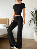 Black high-waist trousers and matching short-sleeve T-shirt co-ord set laid flat.