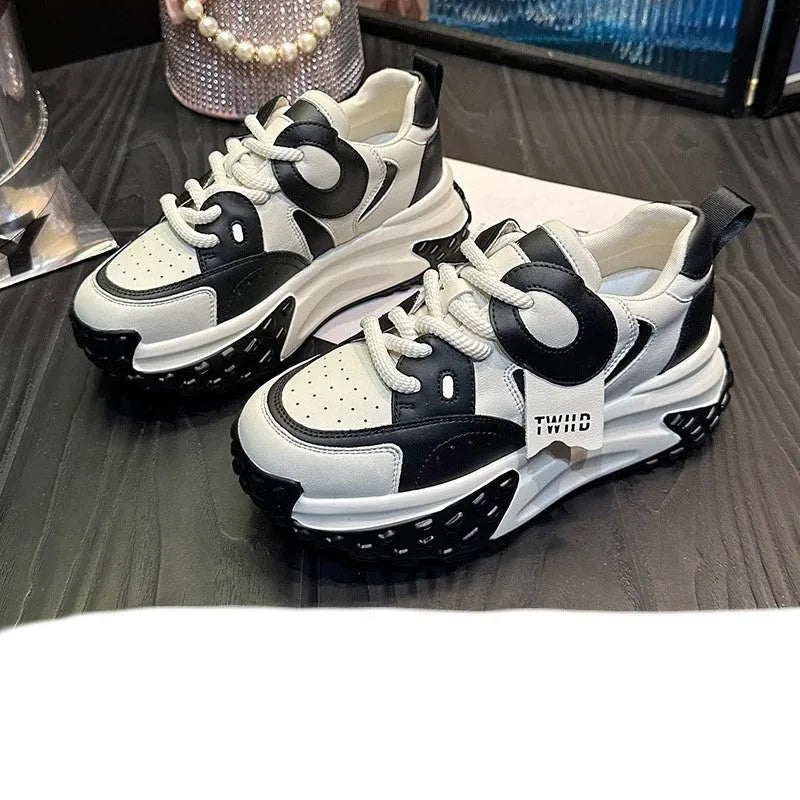 A pair of thick-soled leather casual shoes with a wedge heel and round toe in a lace-up design.