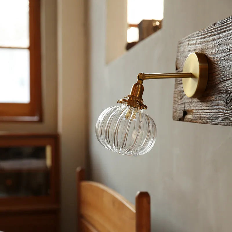 Pumpkin-shaped transparent glass wall lamp mounted on a wall