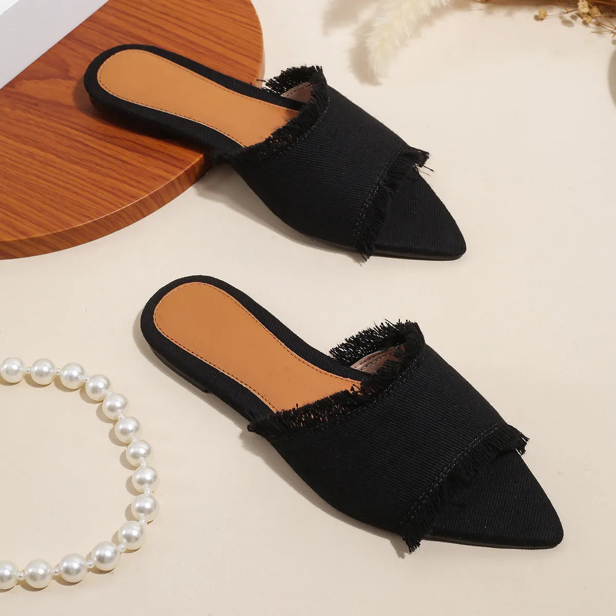 Women's denim flat slippers with tassel detail and leather lining in multiple colours.