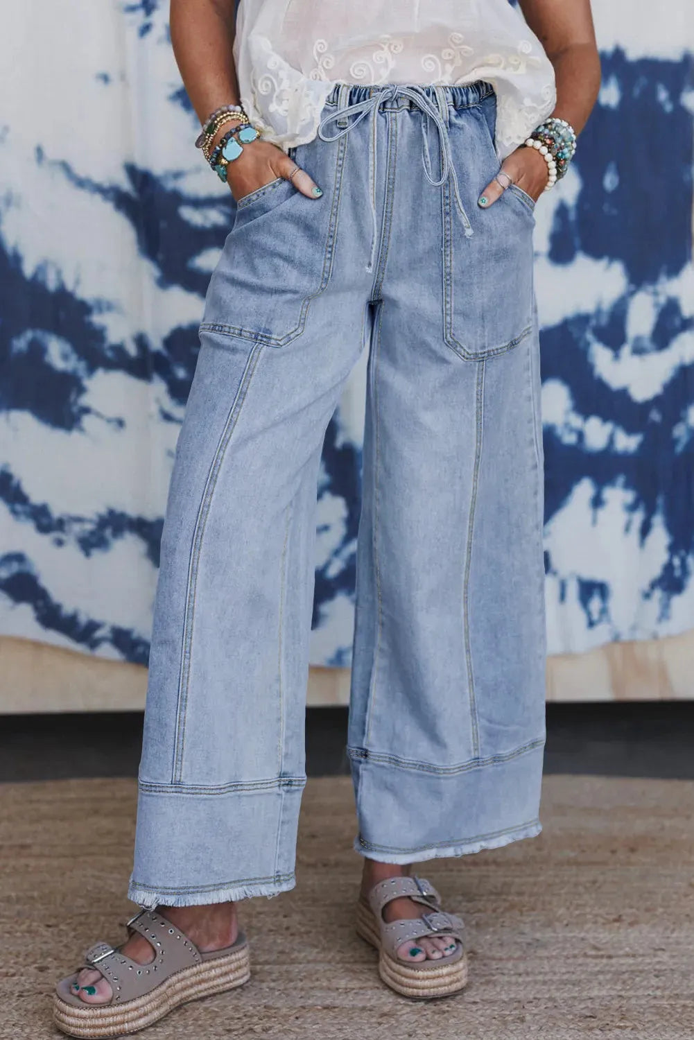 Beau blue wide leg denim trousers with drawstring waist, raw hem finish, and visible seam detailing