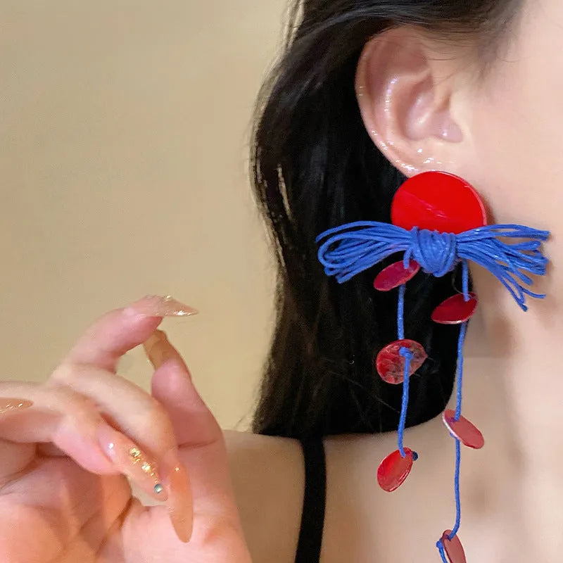 Women's geometric blue and silver fabric drop earrings with a resin flower detail.