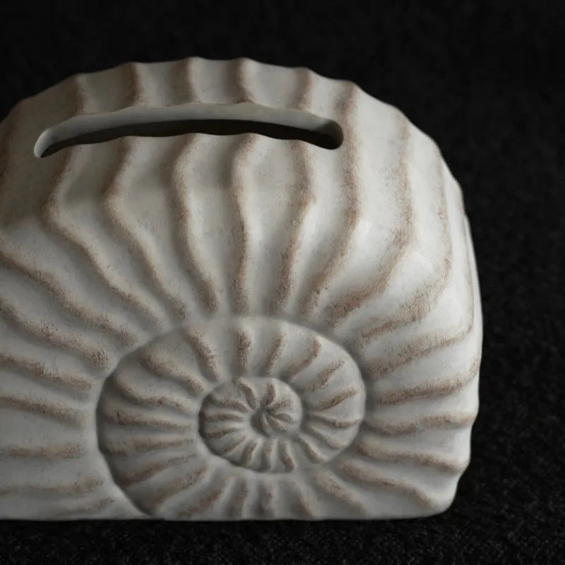 Resin conch seashell tissue box decoration in conch ramble colour on a table.