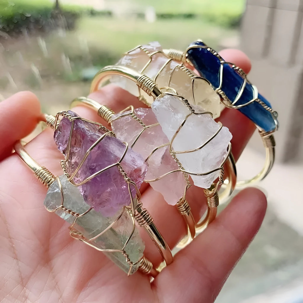 Geometric natural crystal bracelet with gold metal winding on a wrist.
