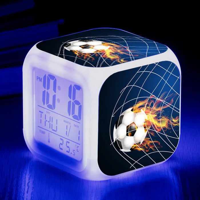 Square plastic alarm clock with a cartoon football pattern, showing silent vibrating alarm models.