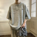 Men's grey short sleeve t-shirt with a raised white 3D letter pattern on the chest