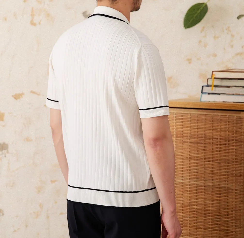 Man wearing a slim black polo shirt with a lapel collar and short sleeves.