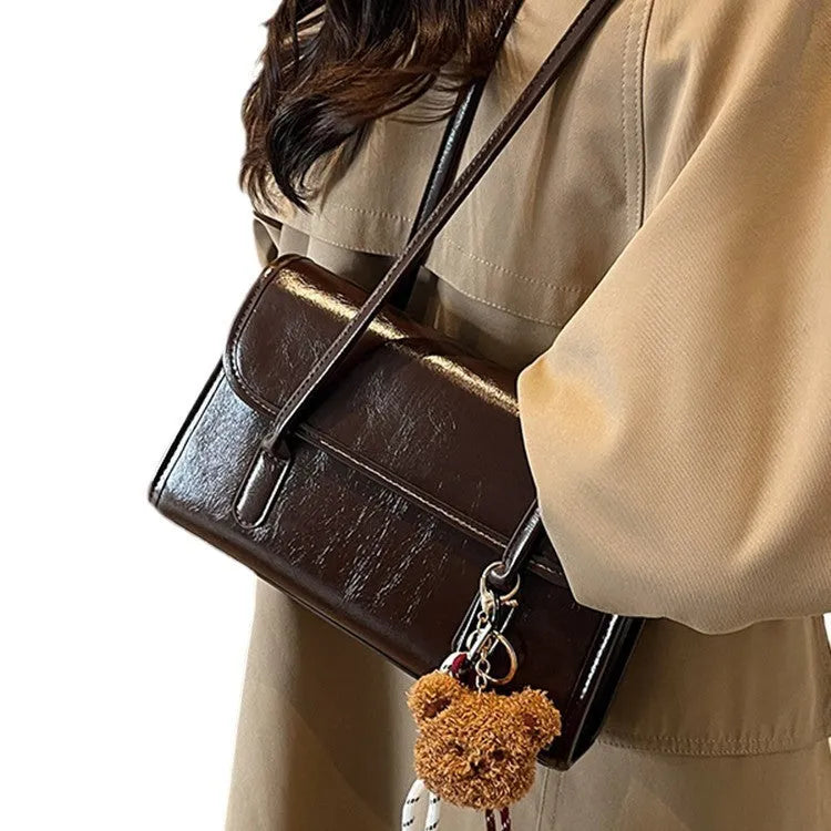 Brown women's structured square PU leather shoulder bag with a detachable tassel pendant and double straps.