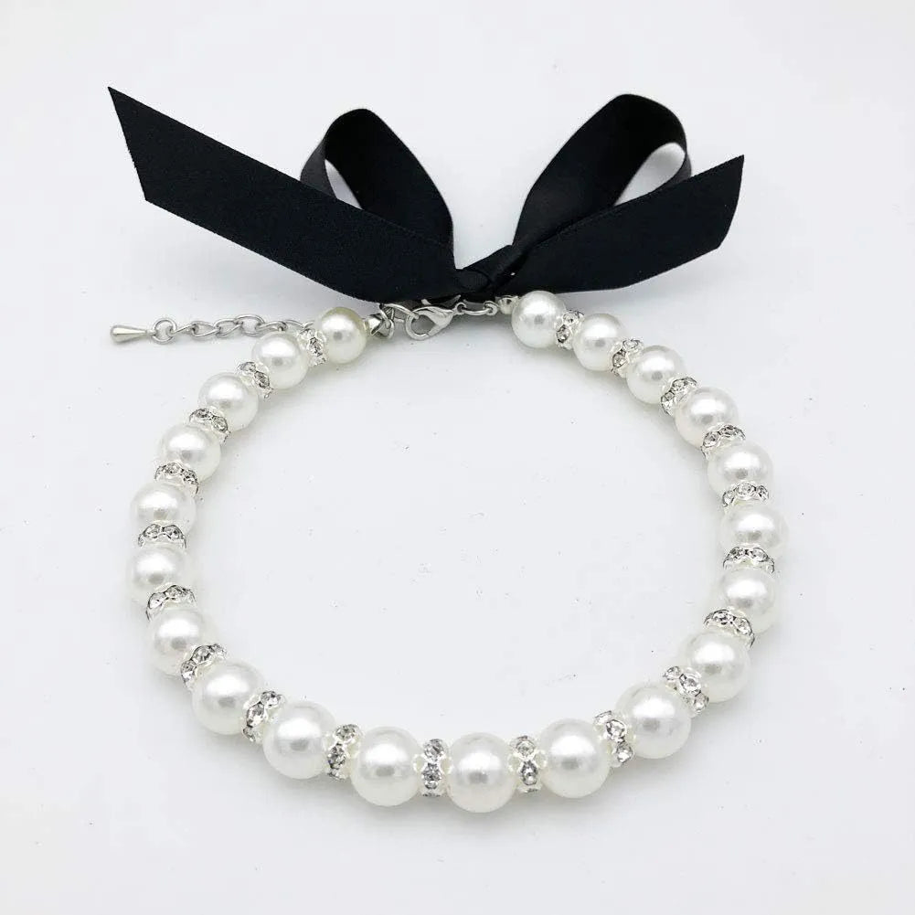 Adjustable diamond dog pearl necklace with rhinestones and ribbon bow in blue, pink, purple, or white.
