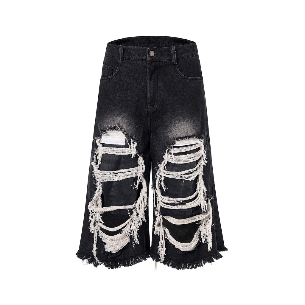Black wide-leg cropped jeans with ripped patch detail on the legs, showing a mid-high waist and loose fit.