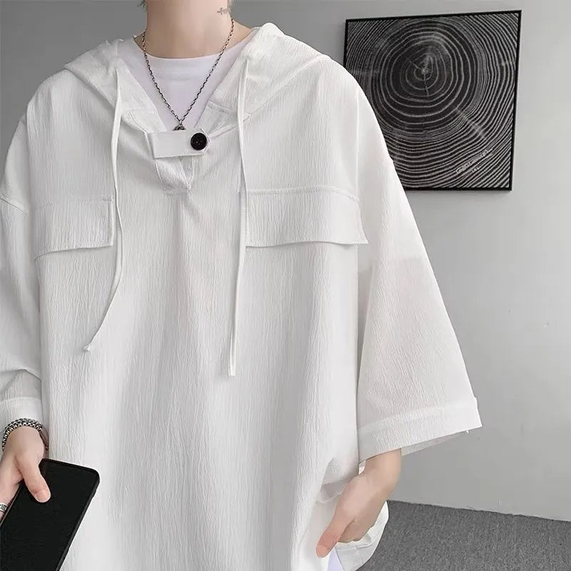 Man modelling a loose grey hooded short sleeve t-shirt, showing the pullover style and front design.