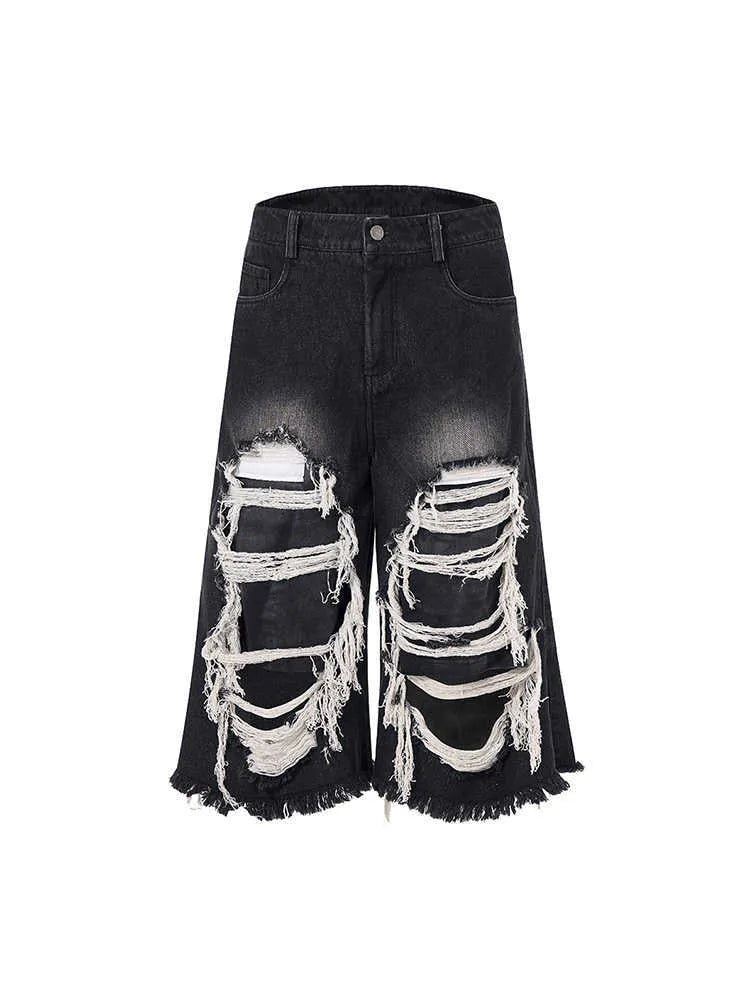 Black wide-leg cropped jeans with ripped patch detail on the legs, showing a mid-high waist and loose fit.