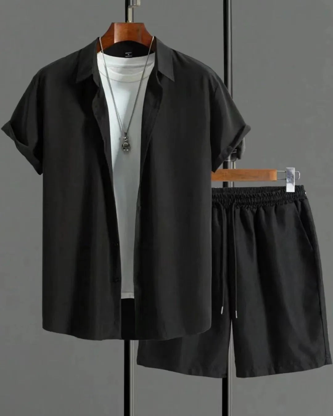 Man wearing a grey jacquard short-sleeve suit jacket and matching shorts.