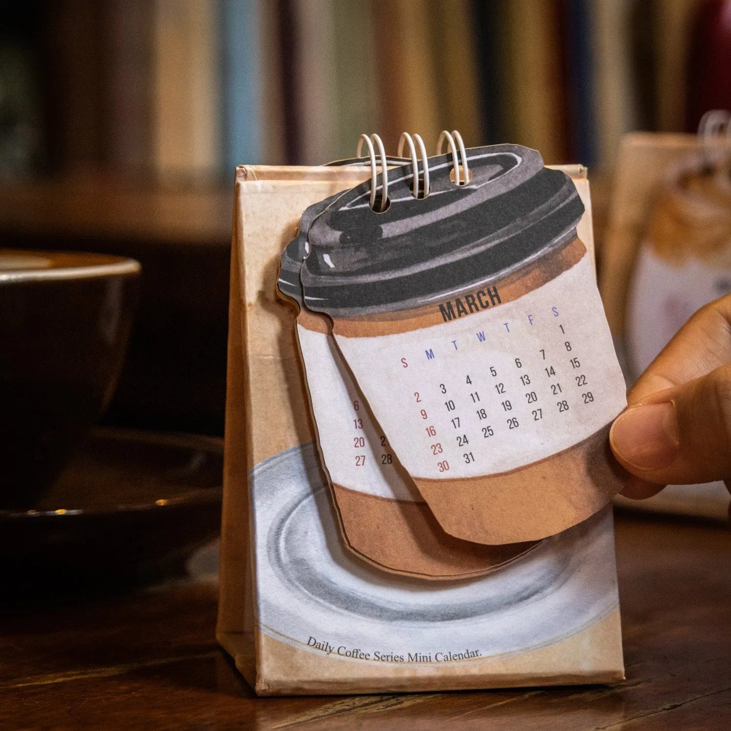 Mini 2025 desk calendar in a simple modern design on a wooden desk