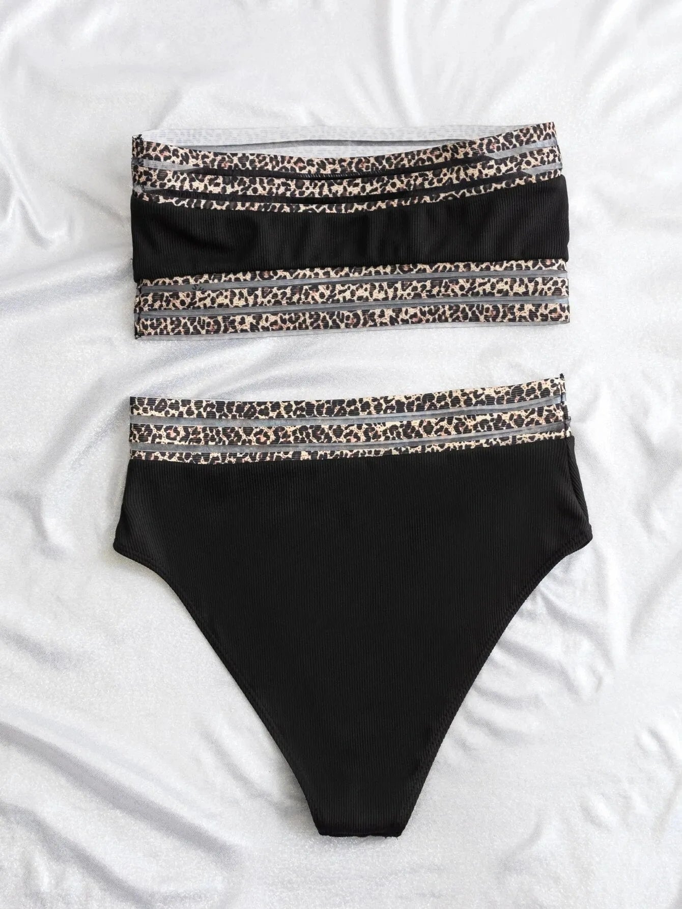 Black strapless split swimsuit with leopard print detail on a mannequin.