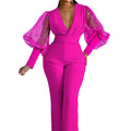 Red women's jumpsuit with mesh stitching detail on the bodice, long sleeves, and wide leg trousers.