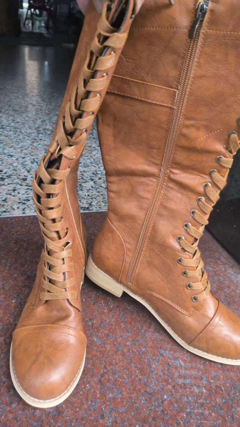 Women's black knight ankle boots with a cross strap design over the instep.