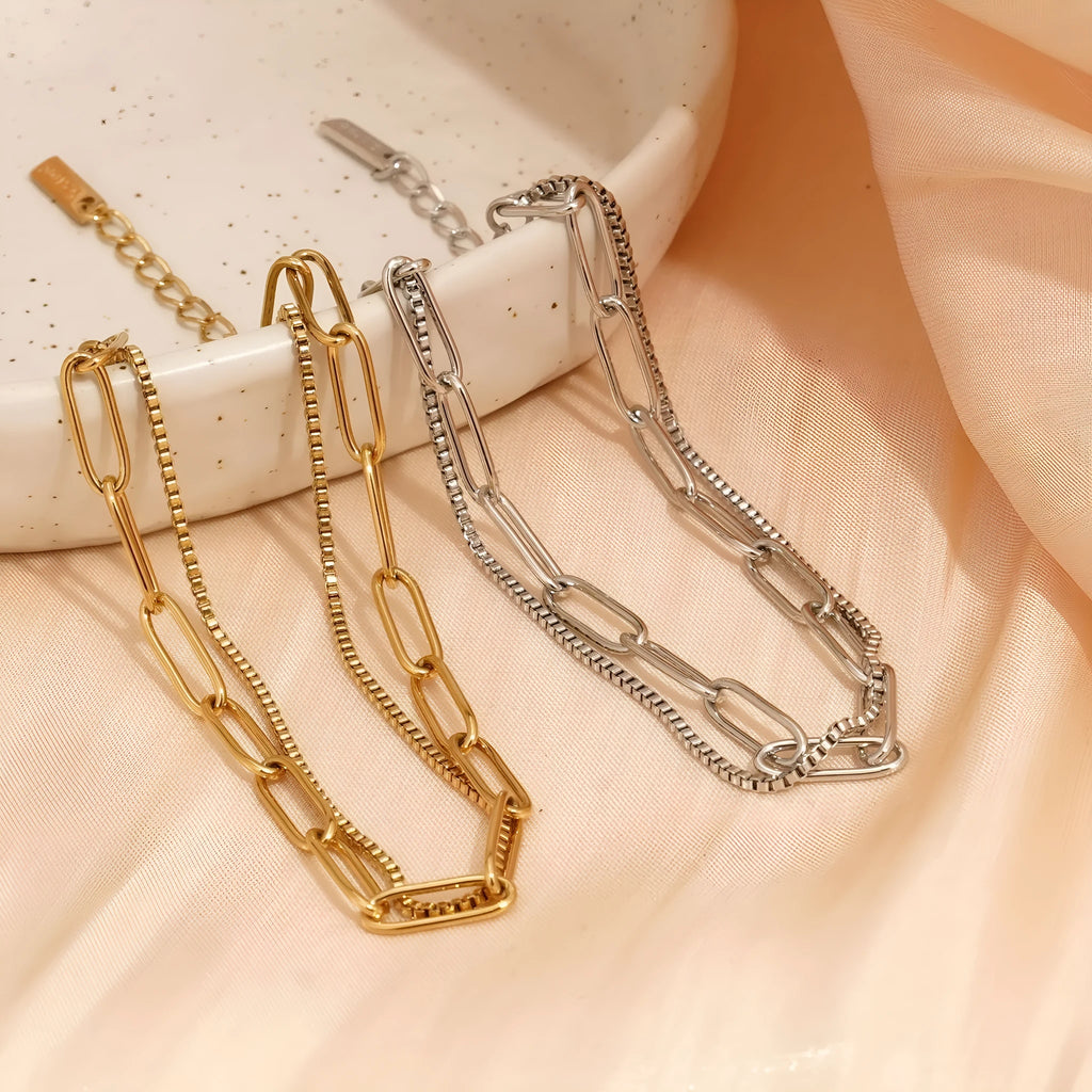 Gold titanium steel electroplated women's bracelet with geometric double layer chain design.