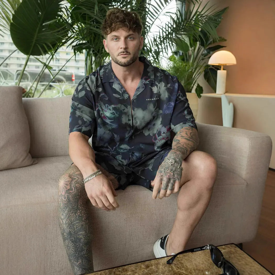 Man wearing a loose grey short sleeve cardigan top with a white floral print pattern.