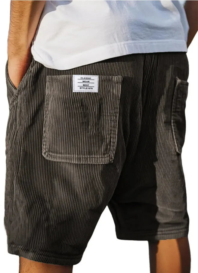 Men's grey corduroy shorts with embroidered detail on multiple pockets, laid flat.
