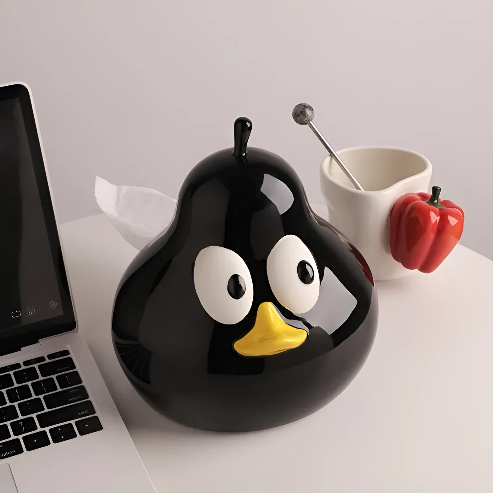 White ceramic pear-shaped tissue box in green or black colour on desktop