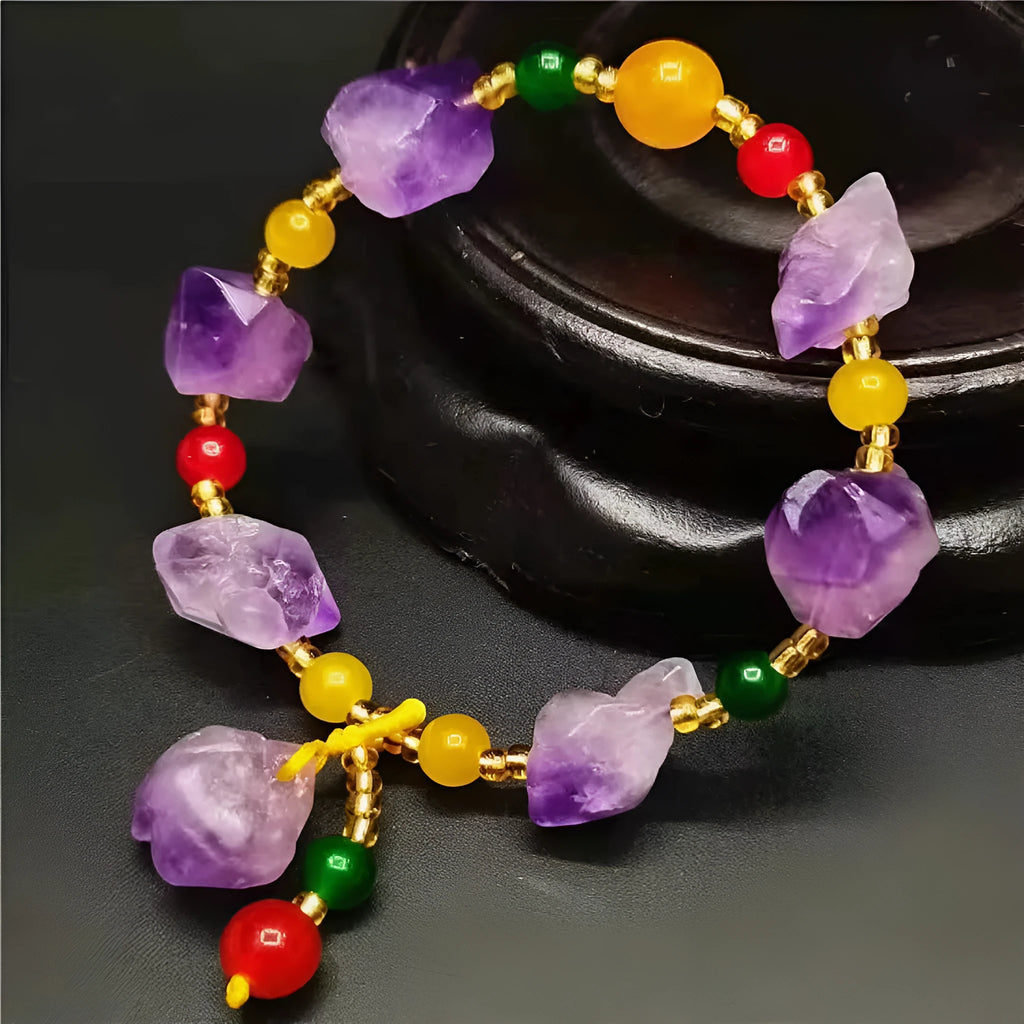 Close-up of a purple natural amethyst bead bracelet with a fu charm for women, on a white background.