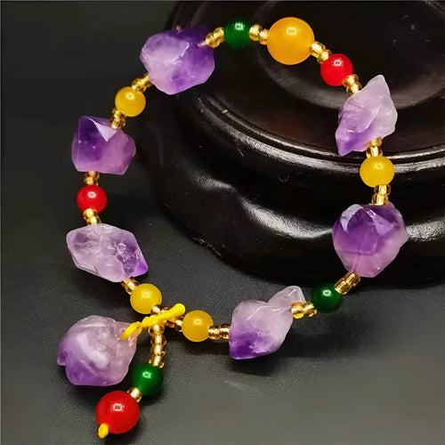 Close-up of a purple natural amethyst bead bracelet with a fu charm for women, on a white background.