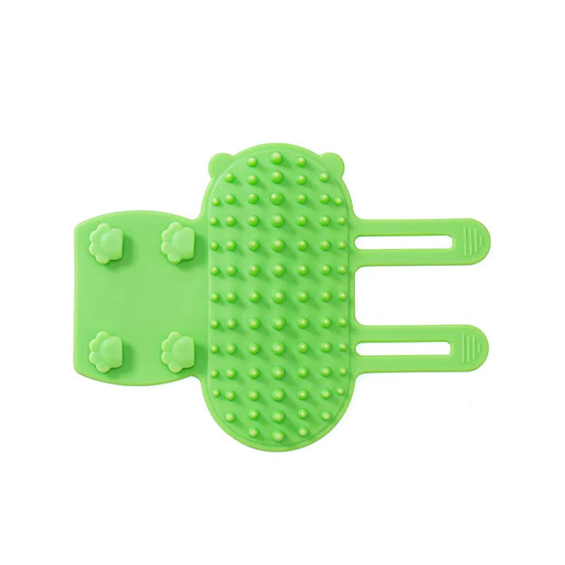 Silicone cat grooming comb with adjustable strap mounted on a table leg, shown in assorted colours.
