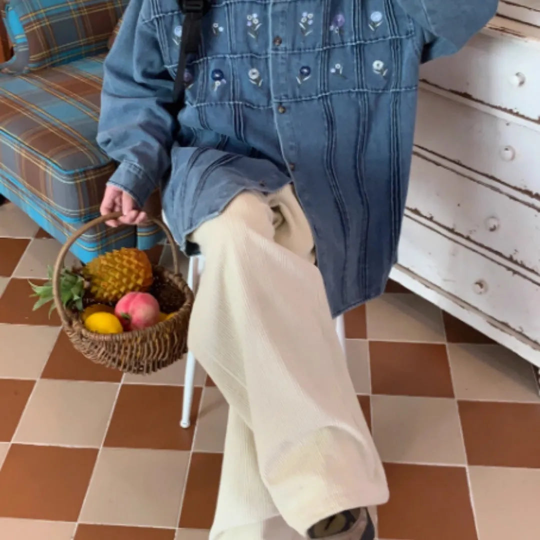 Washed blue denim long sleeve shirt with small floral pleated details on front.