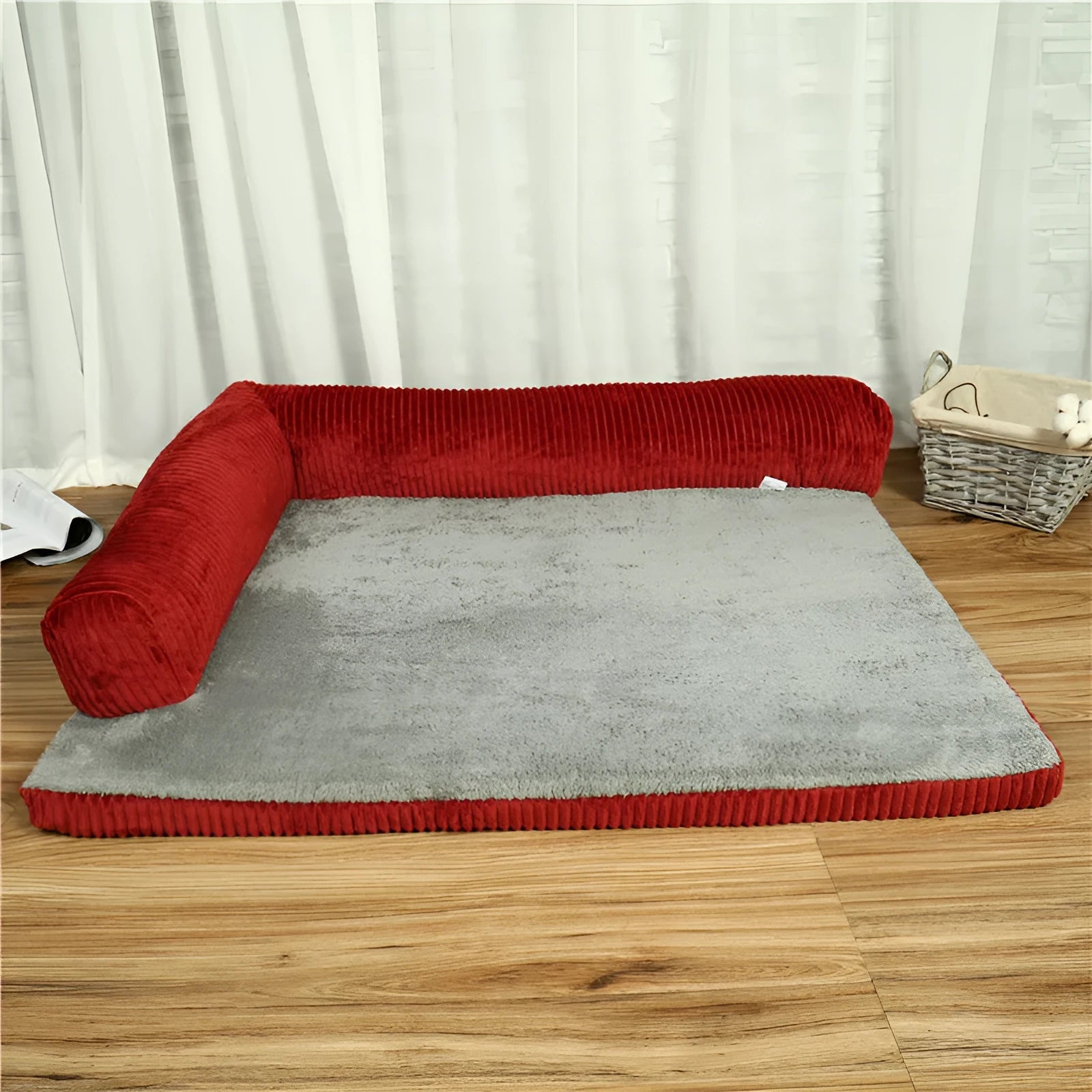Corduroy dog sofa bed in grey, showing high sides and non-slip base, placed on a wooden floor.