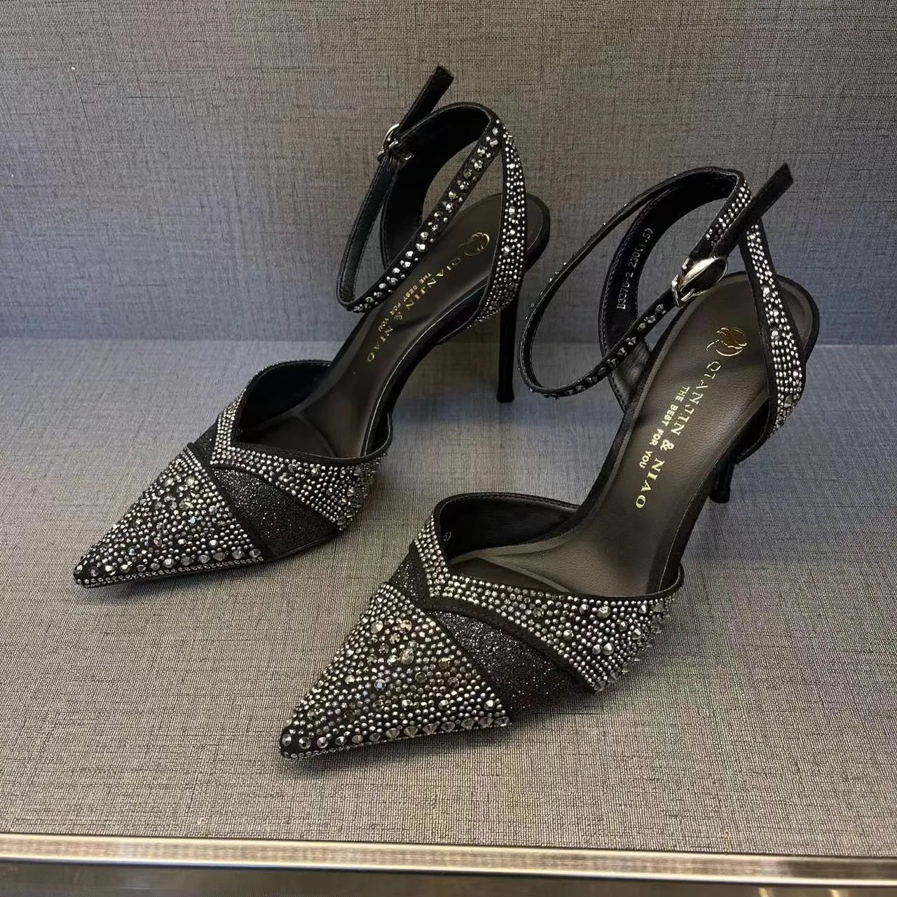 Women's black hollow high heels with red sole, stiletto heel and pointed toe design