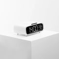White wireless charger Bluetooth speaker alarm clock with LED night light on bedside table